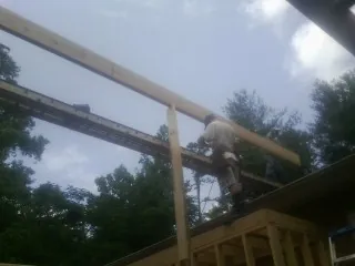 Carpenter setting a ridge beam over a new addition frame — Ice Dam Removal by Roofing Brothers in Chimacum