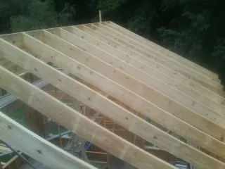 New roof rafters set over an addition before sheathing in Chimacum